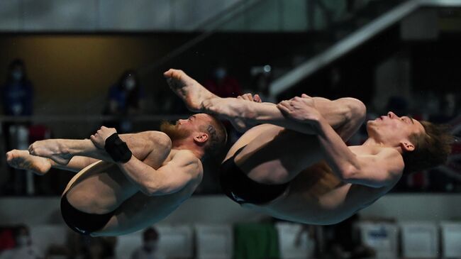 Russia's Nikita Shleikher (R) and Russia's Evgenii Kuznetsov compete in the Men's Synchronised 3m Springboard Diving event during the LEN European Aquatics Championships at the Duna Arena in Budapest on May 13, 2021. (Photo by Attila KISBENEDEK / AFP)