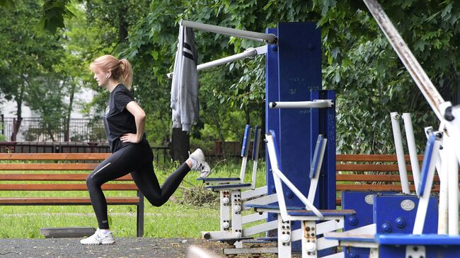 Женщина занимается спортом на школьном стадионе