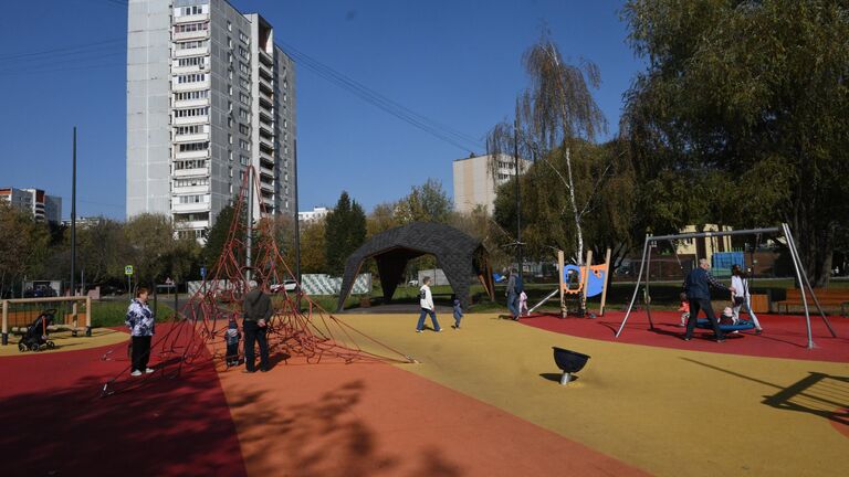 Люди с детьми гуляют на детской площадке в парке Яуза Люди с детьми гуляют на детской площадке в парке Яуза