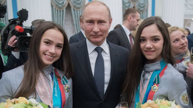 Президент РФ Владимир Путин и призеры женского фигурного катания XXIII зимних Олимпийских игр в Пхенчхане Алина Загитова (слева) и Евгения Медведева после церемонии вручения государственных наград спортсменам в Кремле