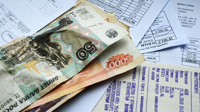 Денежные купюры и квитанции за оплату коммунальных услуг