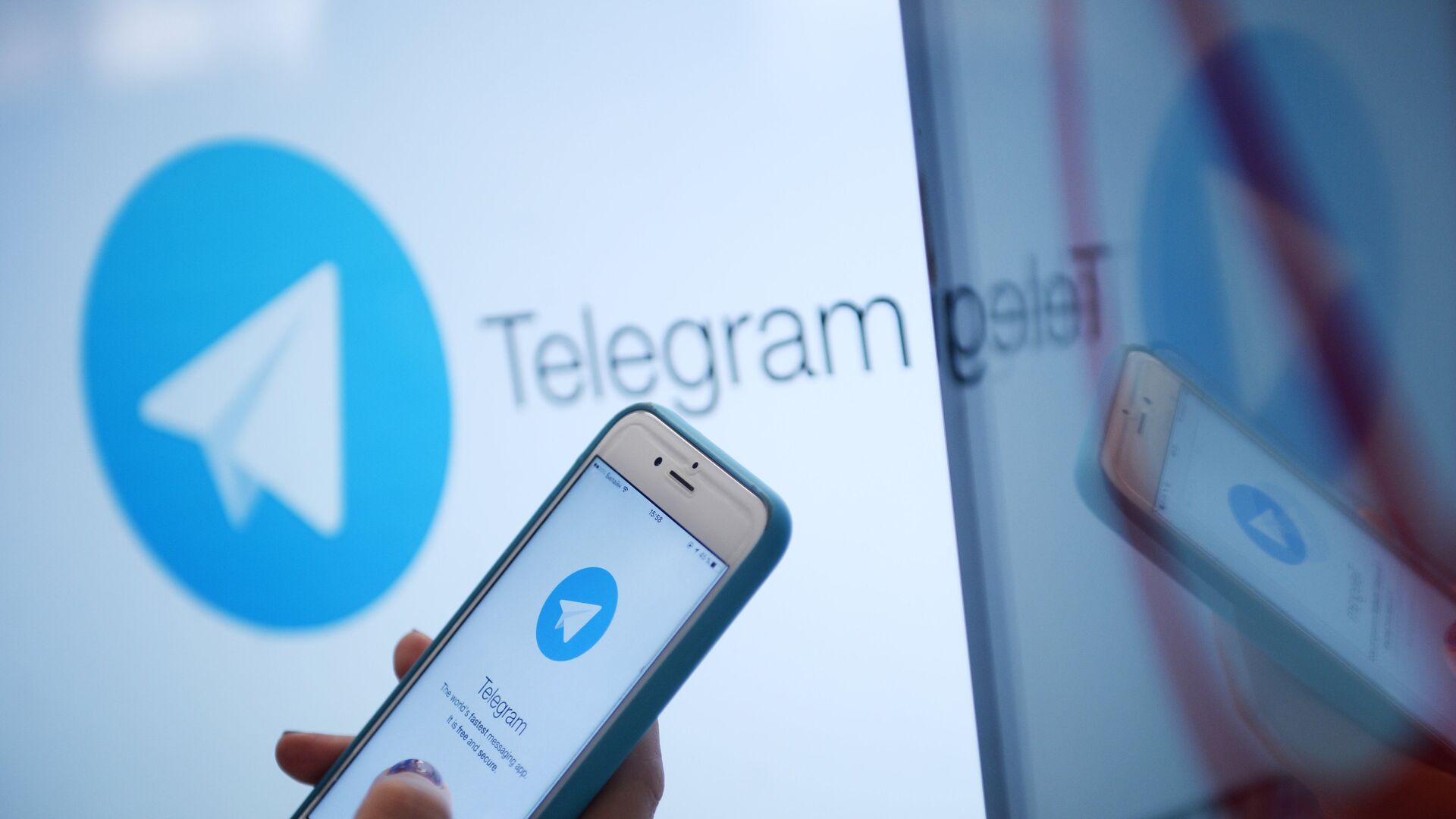 Логотип мессенджера Telegram на экране монитора и телефона - РИА Новости, 1920, 19.05.2025